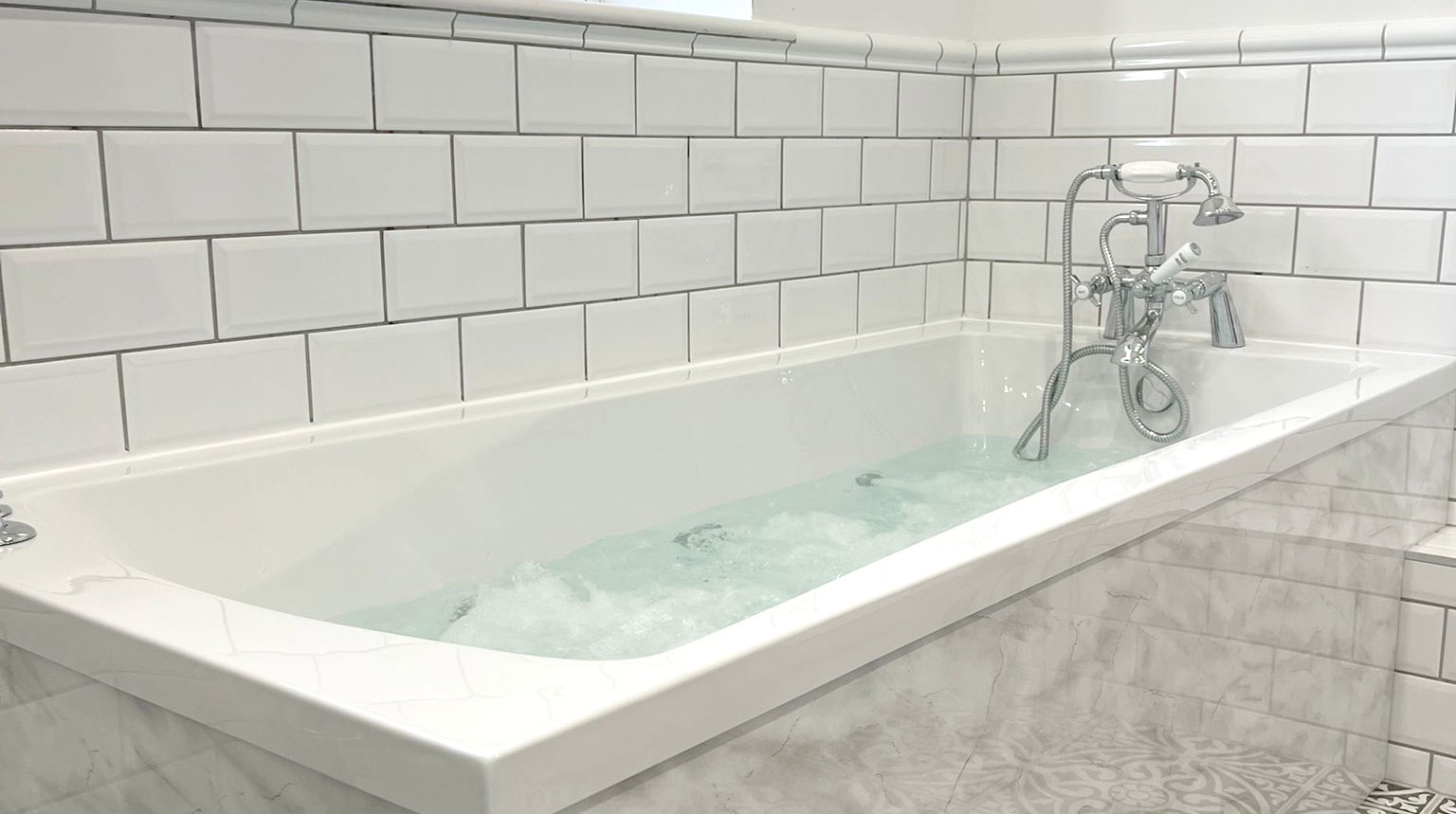 Jacuzzi bath with white tiles